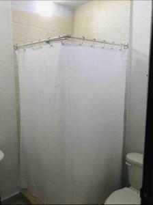 łazienka z białą zasłoną prysznicową i toaletą w obiekcie Loft Hermoso en Guadalupe w mieście Monterrey