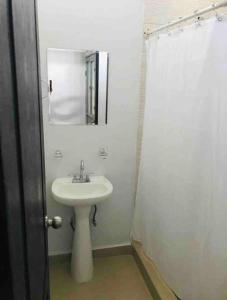 a white bathroom with a sink and a mirror at Loft Hermoso en Guadalupe in Monterrey