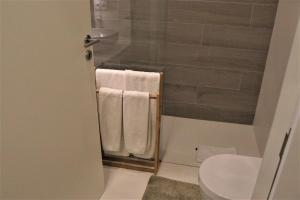 ein Bad mit einer Dusche, Handtüchern und einem WC in der Unterkunft ORM - São Lazaro Apartment in Porto