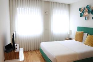 ein Schlafzimmer mit einem großen Bett und einem TV in der Unterkunft ORM - São Lazaro Apartment in Porto