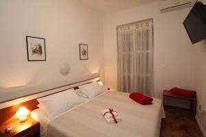 1 dormitorio con 1 cama con arco rojo en Vincent apt. in old town centre, en Zadar