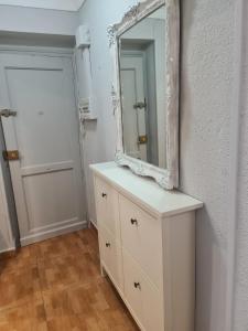 een spiegel bovenop een dressoir in een kamer bij Apartamento Zaragoza Plaza Europa in Zaragoza