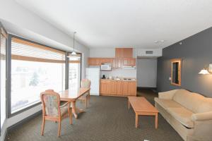 uma cozinha e sala de estar com uma mesa e um sofá em Prime Hotel em Fort McMurray