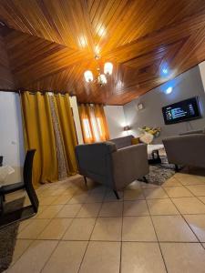 a living room with a couch and a tv at AU COEUR DE BONAMOUSSADI-WIFI-PARKING-GARDIENS-24H in Douala