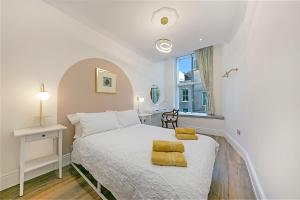a bedroom with a white bed with yellow towels on it at Market Street Apartments ✪ Grampian Lettings Ltd in Aberdeen