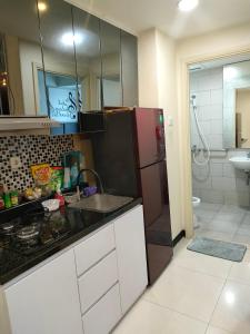 La cuisine est équipée d'un évier et d'un réfrigérateur. dans l'établissement Amore Apartment, à Kalisari