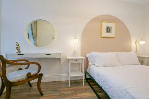 a bedroom with a bed and a chair and a mirror at Market Street Apartments ✪ Grampian Lettings Ltd in Aberdeen