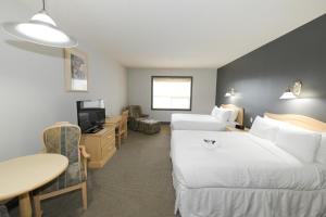 um quarto de hotel com duas camas e uma mesa em Prime Hotel em Fort McMurray