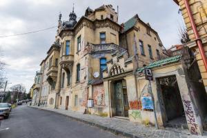 un antiguo edificio al lado de una calle en Central Park Residence, en Brasov