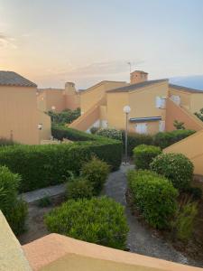 - une vue depuis le balcon d'un immeuble avec des buissons dans l'établissement Joli appartement mezzanine avec parking et wifi La Roquille, au Cap d'Agde