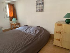 - une chambre avec un lit et une commode avec une lampe dans l'établissement Joli appartement mezzanine avec parking et wifi La Roquille, au Cap d'Agde