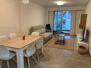 een woonkamer met een tafel en een bank bij RESIDENCIAL ILLAS ATLANTICAS en SANXENXO in Portonovo