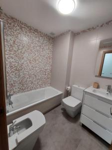 W łazience znajduje się toaleta, wanna i umywalka. w obiekcie RESIDENCIAL ILLAS ATLANTICAS en SANXENXO w mieście Portonovo