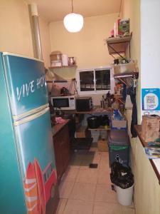 an office with a desk and a refrigerator in a room at Chenille House HOSTAL con jardín y AC in Munro