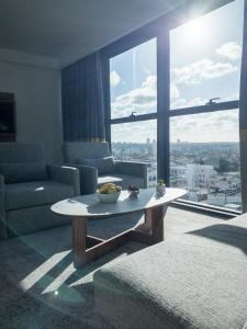 a living room with a table in front of a large window at New Hotel Piscine Wellness & Spa in Casablanca