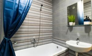 une salle de bain avec un lavabo et une baignoire et un lavabo dans l'établissement Central Fenix apartment - Free private parking-Fast WI-FI, à Novi Sad 30 autres photos