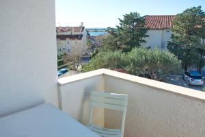 a white chair sitting on the ledge of a balcony at Apartments Summer Joy in Novalja