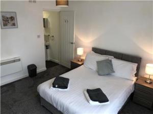 Upper Ashby Apartments في Brumby: غرفة نوم عليها سرير وفوط
