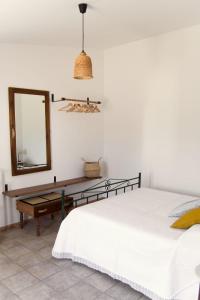 a bedroom with a bed and a mirror and a table at Trulli Cibelis in Noci