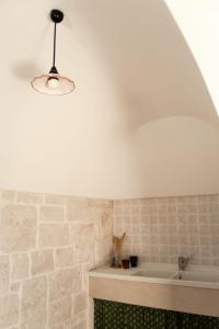 a bathroom with a bath tub and a light fixture at Trulli Cibelis in Noci