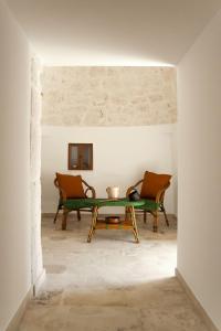 Trulli Cibelis في نوتشي: غرفة معيشة مع طاولة وكرسيين