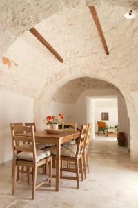 Trulli Cibelis في نوتشي: غرفة طعام مع طاولة وكراسي خشبية