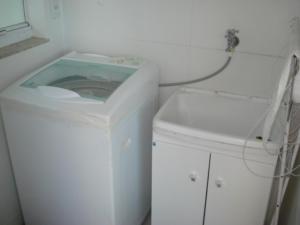 baño con lavabo y lavadora blanca en Apartamento frente mar, en Balneário Camboriú