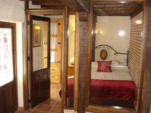 1 dormitorio con 1 cama con marco de madera en Apartamentos Azahar, en Mogarraz