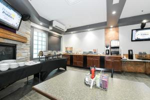 a restaurant with a kitchen with tables and a counter at Prime Hotel in Fort McMurray