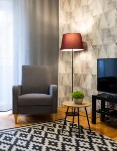 un soggiorno con sedia e TV di Central Fenix apartment - Free private parking-Fast WI-FI a Novi Sad