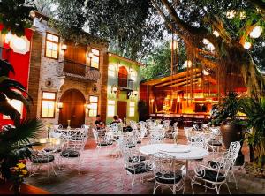 a patio with white tables and chairs in front of a building at D’Waldz Villa 2 Tagaytay in Tagaytay
