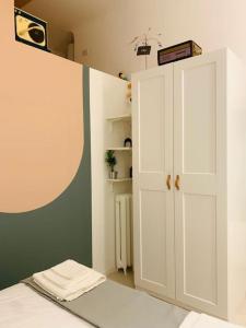 a bedroom with a white cabinet and a bed at Stylish flat in Porta Romana-Fondazione Prada in Milan