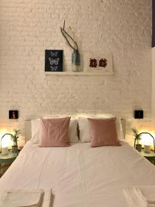 a white bed with pink pillows in a bedroom at Stylish flat in Porta Romana-Fondazione Prada in Milan
