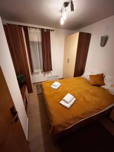 a bedroom with a bed with two towels on it at Vikendica Gradina Zlatibor in Čajetina