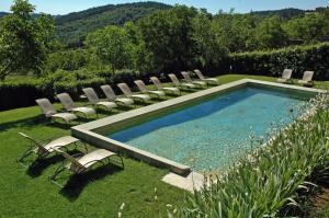 una piscina con sedie a sdraio e una piscina di Hotel Palazzo Squarcialupi a Castellina in Chianti