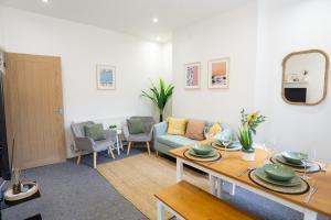 uma sala de estar com uma mesa e um sofá em Air Host and Stay - Cedar House - sleeps 7, parking, 8 mins to city em Liverpool