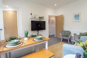 uma sala de estar com uma mesa e uma televisão em Air Host and Stay - Cedar House - sleeps 7, parking, 8 mins to city em Liverpool