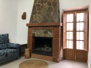 a living room with a brick fireplace and a door at Cortijo los Garridos - 7 huéspedes in Almería