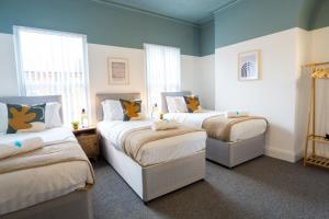 Duas camas num quarto com paredes azuis em Air Host and Stay - Cedar House - sleeps 7, parking, 8 mins to city em Liverpool