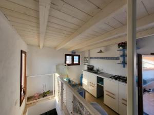 a kitchen with white walls and wooden ceilings at Perla del mare in Calasetta