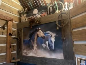 uma pintura de cavalos numa parede num quarto em Fox Pass Cabins em Hot Springs