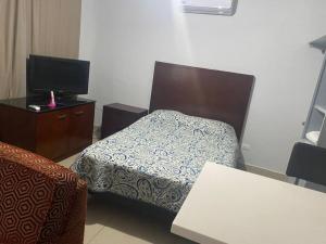 ein Hotelzimmer mit einem Bett und einem TV in der Unterkunft Loft Hermoso en Guadalupe BBVA in Monterrey