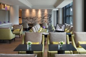 a restaurant with tables and chairs and a wall with a map at Renaissance Paris La Defense Hotel in Puteaux