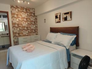 a bedroom with a bed with two towels on it at Barra Garden Happy - Condomínio Barra Village Lakes tipo Resort - Recreio dos Bandeirantes in Rio de Janeiro