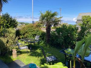 a patio with a table and chairs and a palm tree at Beechwood House in St Ives
