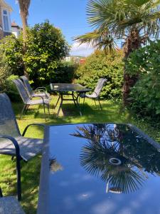 a glass table with chairs and a table with a palm tree at Beechwood House in St Ives +22 photos