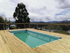 una piscina en la parte superior de una terraza de madera en Finca Villa Sofia en El Peñol
