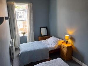 a small bedroom with two beds and a window at Entire Loddon Apartment in Loddon
