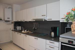 a kitchen with white cabinets and a counter top at Le TOM de ROYAN in Royan