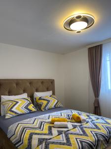 een slaapkamer met een bed met een gele en blauwe deken bij Vucinic Studio Apartment in Cetinje